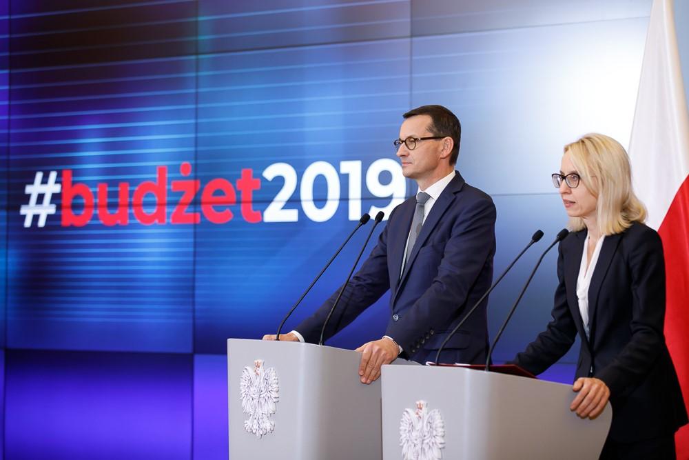 Premier Mateusz Morawiecki i minister Teresa Czerwińska stoją przy mównicach.