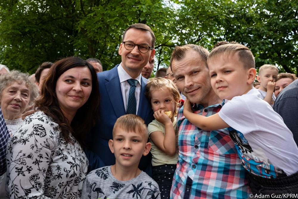 Premier Mateusz Morawiecki pozuje do zdjęcia z uczestnikami festynu.
