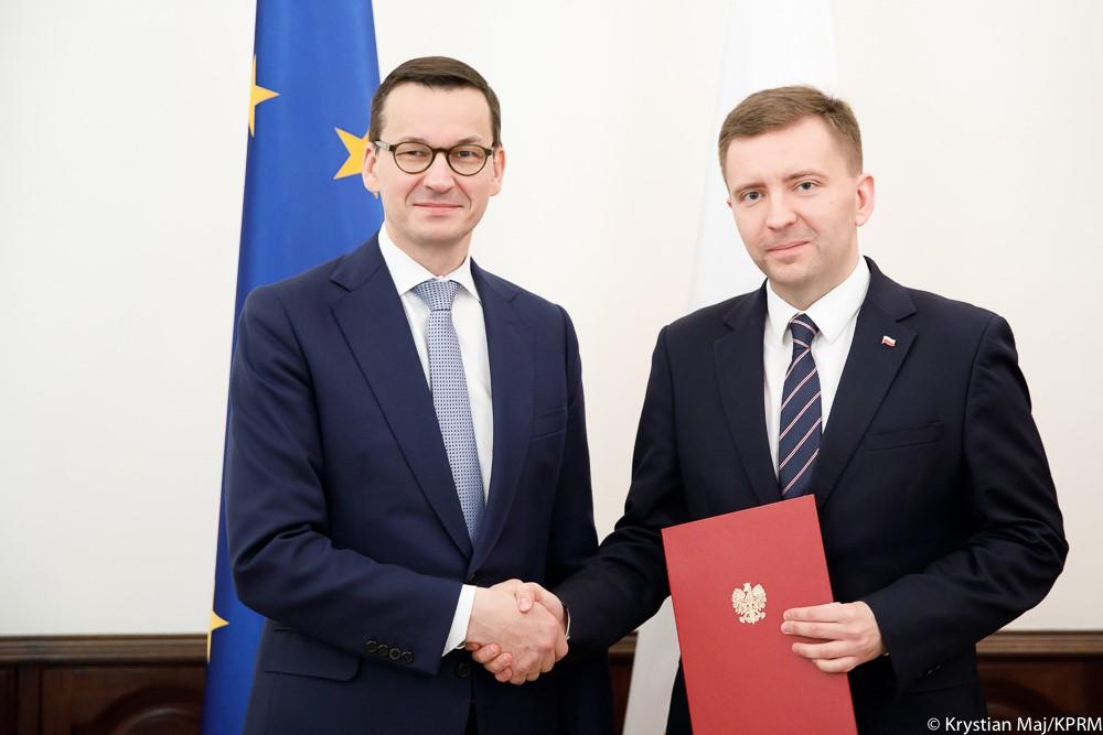Premier Mateusz Morawiecki ściska dłoń Łukasza Schreibera.