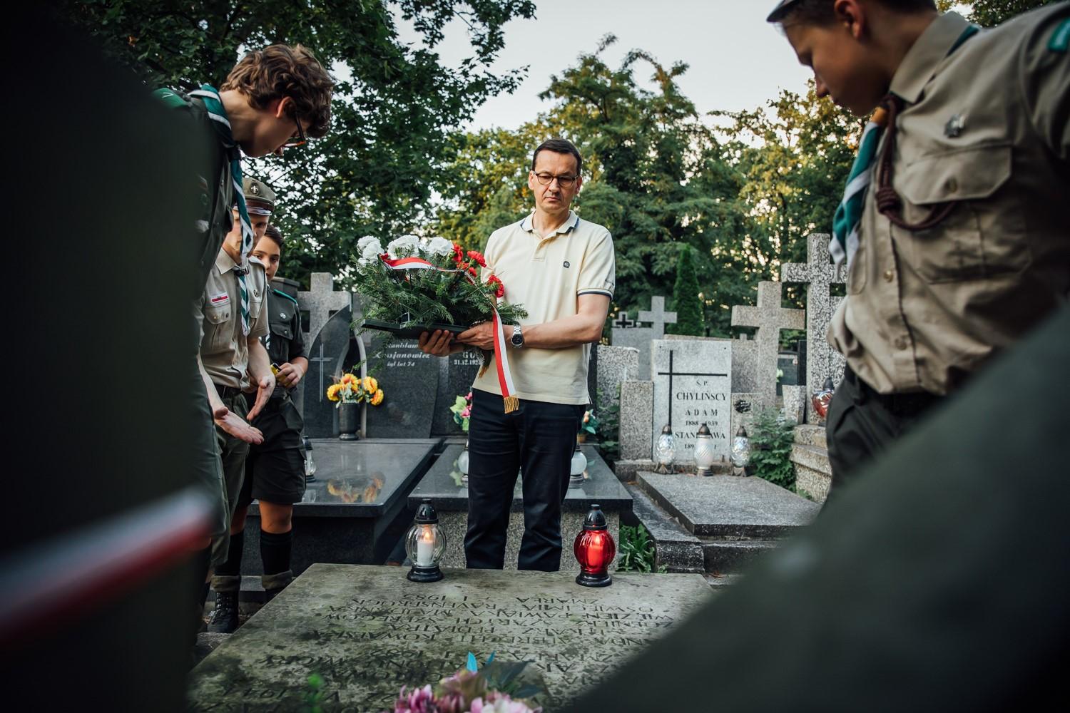 Premier Mateusz Morawiecki stoi zamyślony nad grobem powstańczym.