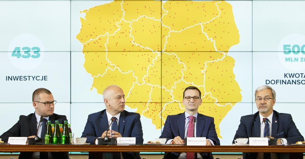 Od lewej: minister Paweł Szefernaker, minister Joachim Brudziński, premier Mateusz Morawiecki, minister Jerzy Kwieciński siedzą przy stole.
