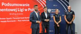 W centralnej części zdjęcia stoi Minister Sportu i Turystyki Kamil Bortniczuk z numerem startowym oraz statuetką Diamentowej Ligi. Po prawej stronie obok ministra stoją Natalia Kaczmarek, Krzysztof Kęcki, oraz Piotr Małachowski. Wszystkie osoby stoją na czerwono-granatowym tle z napisem: Podsumowanie Diamentowej Ligi w Polsce. oraz logotyp Ministerstwa Sportu i Turystyki z hasłem Tworzymy Polski Sport.
