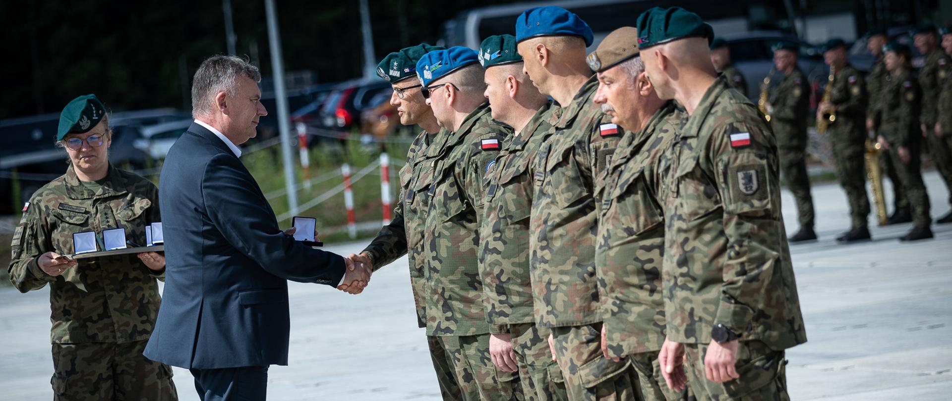 30 lipca 2025 r. na terenie Ośrodka Ćwiczeń Zielona w Karakulach, z udziałem sekretarza stanu w MON Pawła Bejdy odbyło się uroczyste przekazanie dowodzenia między dowódcami II oraz III zmiany Zgrupowania Zadaniowego Podlasie.
30 lipca br. dowodzenie operacją „Bezpieczne Podlasie” przejęła 16 Dywizja Zmechanizowana, która już wcześniej zdobyła cenne doświadczenie w działaniach granicznych. Teraz, jako trzon III zmiany Zgrupowania Zadaniowego „Podlasie”, kolejny raz rozpoczyna zadanie ochrony wschodniej granicy państwa, wykorzystując wiedzę i wnioski z poprzednich lat. Na terenie Ośrodka Ćwiczeń Zielona w Karakulach, w obecności żołnierzy wchodzących w skład II i III zmiany operacji „Bezpieczne Podlasie” oraz dowódców Wojska Polskiego, odbyło się uroczyste przekazanie dowodzenia. 