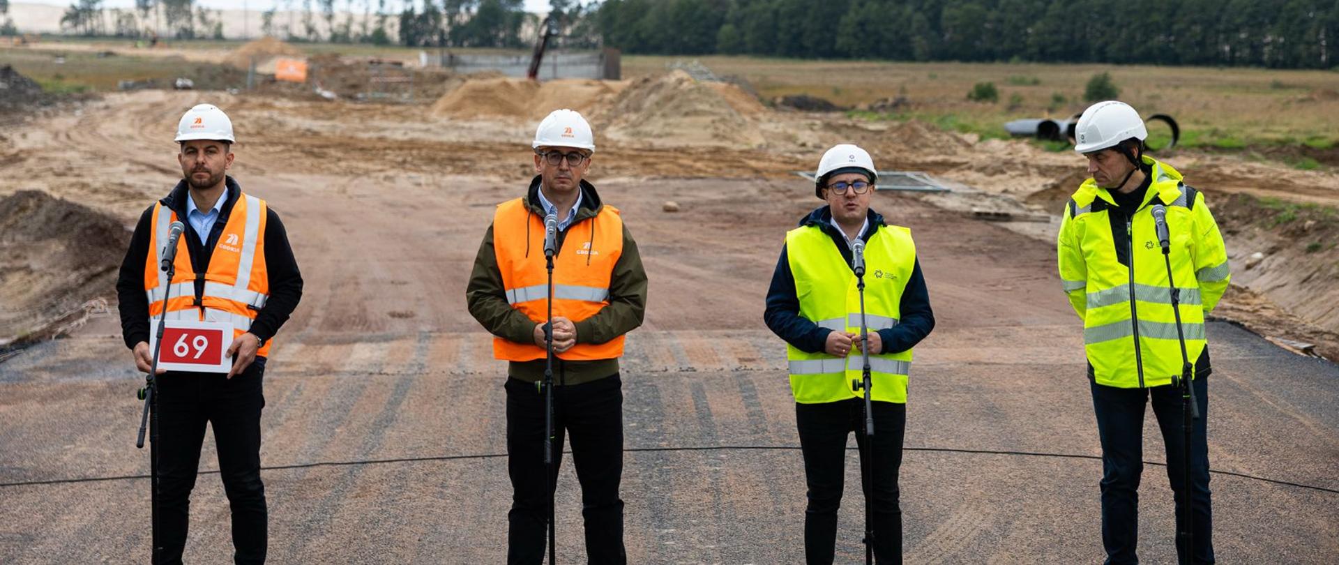 Minister Energii przemawia, stoi z trzema mężczyznami