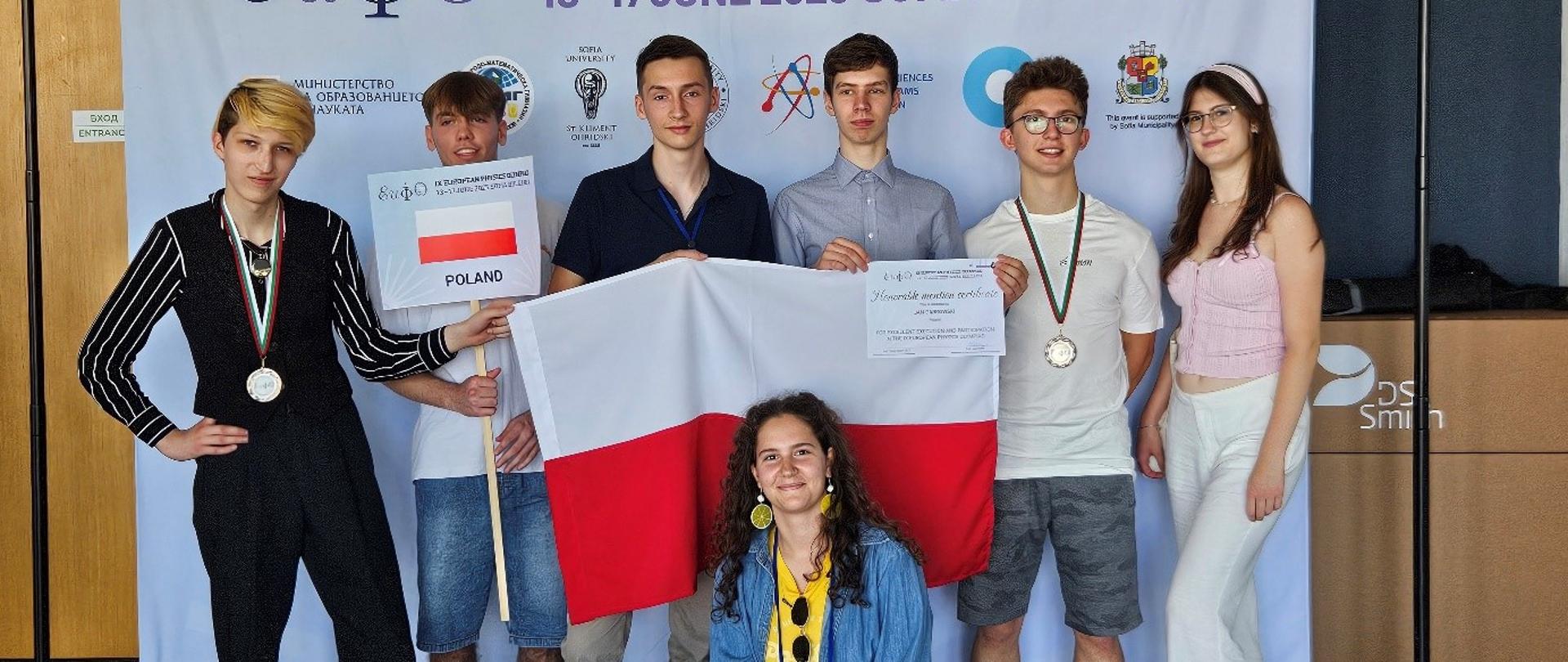 Zdjęcie przedstawia reprezentantów Polski z biało-czerwoną flagą