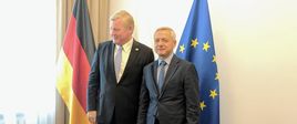Minister M.Zagórski z gościem, w tle flagi