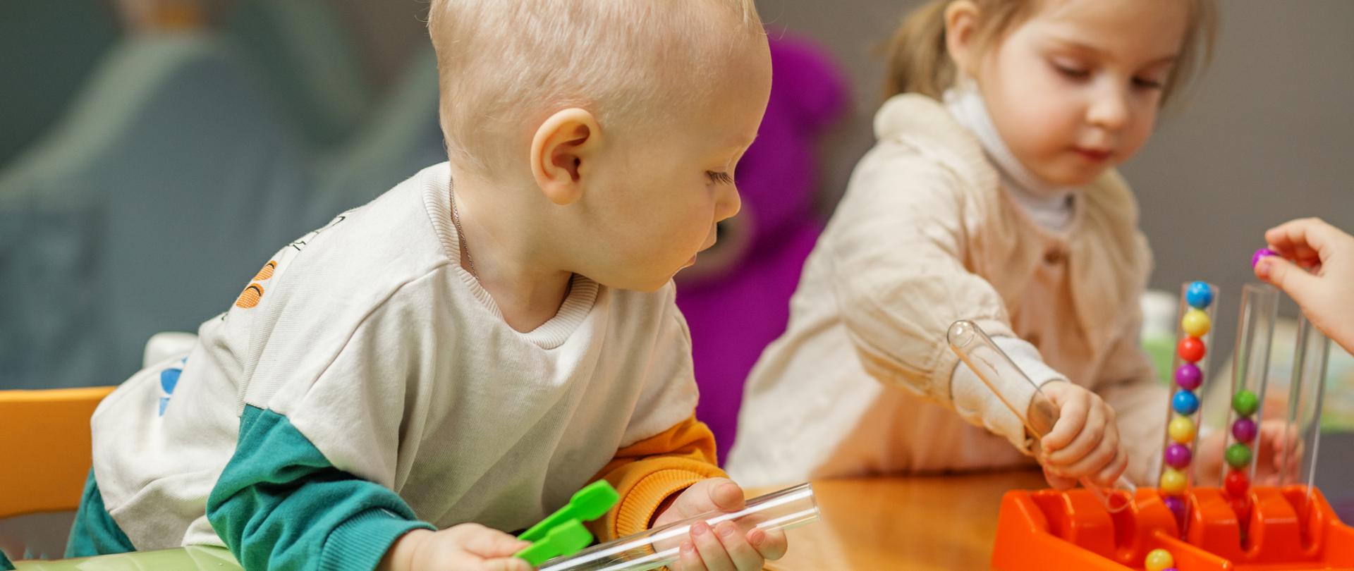 Two young children play together with colorful educational toys, fostering early development and interaction.