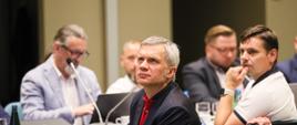 Uczestnicy posiedzenia Rady Dostępności. Pięciu mężczyzn siedzi przy stole konferencyjnym. 