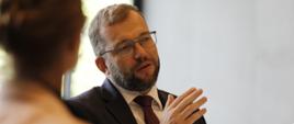 Minister funduszy i polityki regionalnej Grzegorz Puda, minister siedzi przy stole