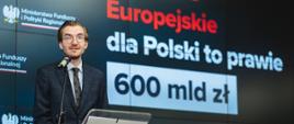 Wiceminister funduszy i polityki regionalnej Jan Szyszko na konferencji prasowej w MFiPR nt. odblokowania środków dla Polski z Funduszy Europejskich, wiceminister stoi przy pulpicie i przemawia do mikrofonu