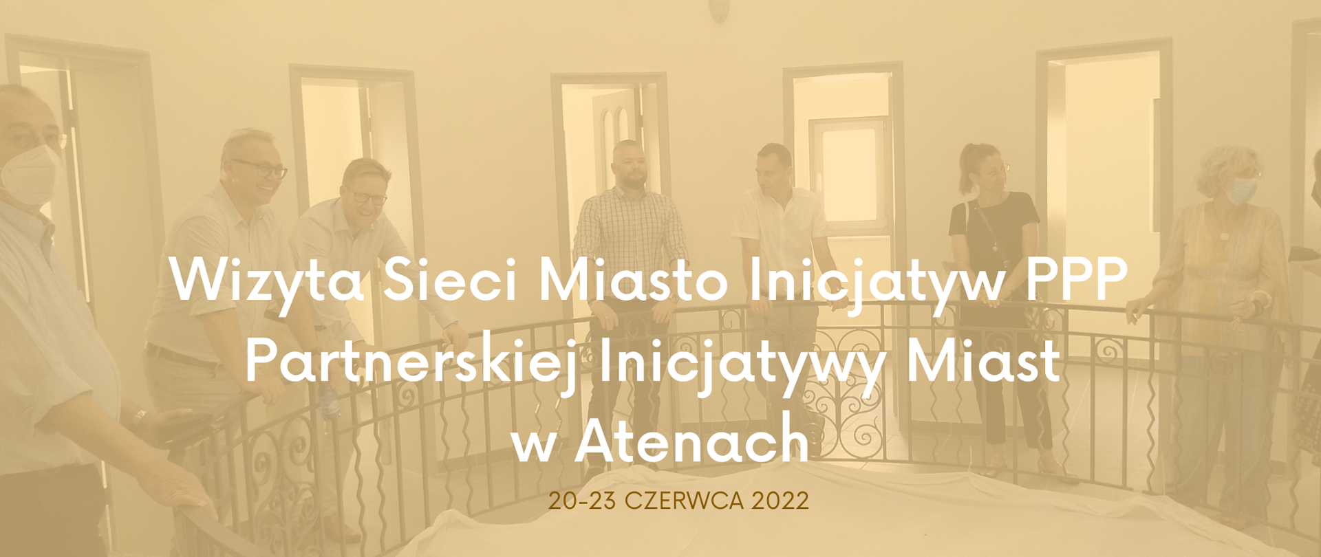 Zdjęcie grupy osób w pomieszczeniu. Na wierzchu zdjęcia napis: "Wizyta Sieci Miasto Inicjatyw PPP Partnerskiej Inicjatywy Miast w Atenach 20--23 czerwca 2022"
