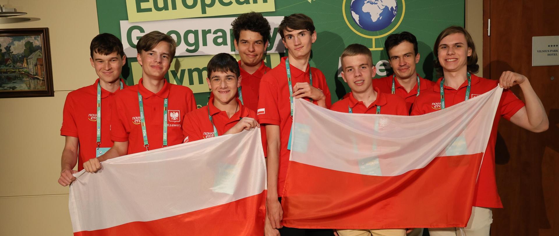 Zdjęcie przedstawia reprezentację Polski trzymającą biało-czerwone flagi