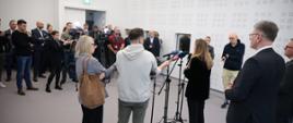 Minister funduszy i polityki regionalnej Katarzyna Pełczyńska-Nałęcz stoi przy mikrofonach, przed nią stoją dziennikarze