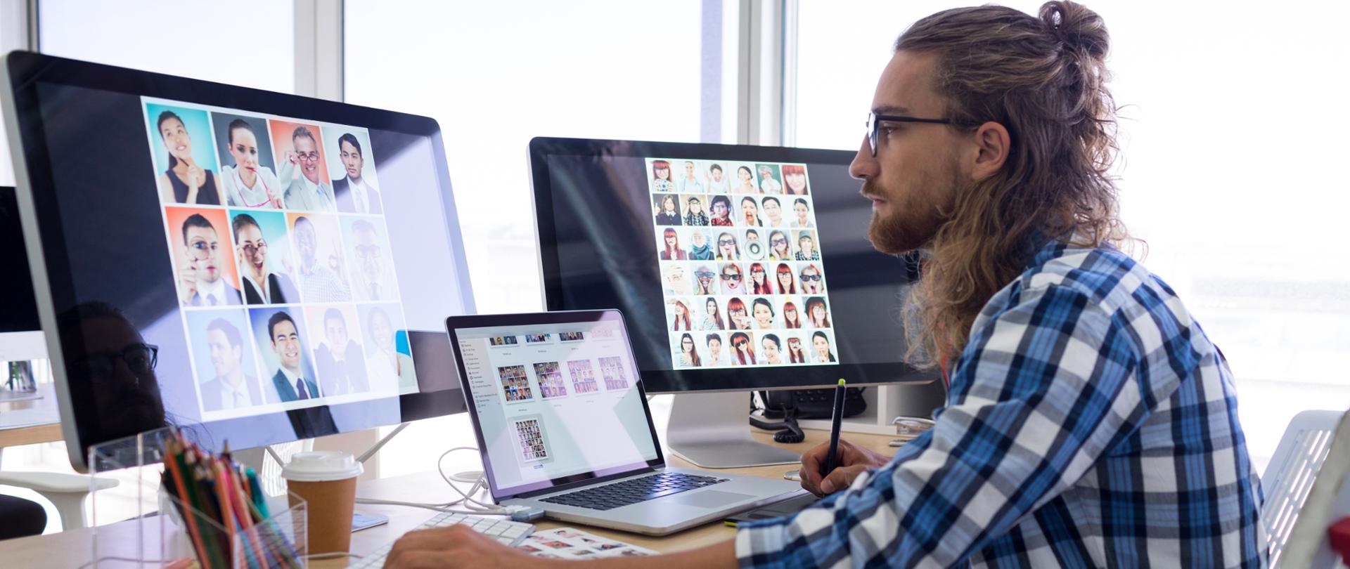 Male executive working over laptop and graphic tablet at his desk in office