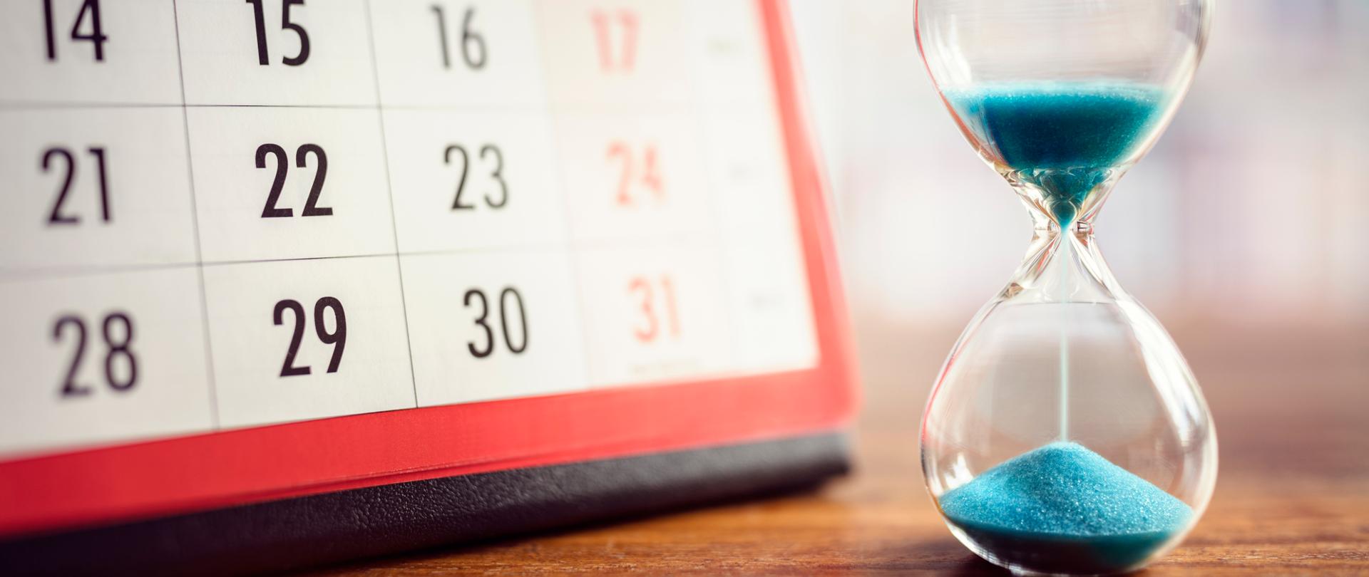 Fragment kartki z kalendarza, obok klepsydra