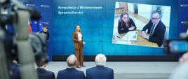 Minister funduszy i polityki regionalnej Katarzyna Pełczyńska-Nałęcz stoi na scenie, za jej plecami ekran z fotografią na której jest minister Pełczyńska-Nałęcz i minister sprawiedliwości Adam Bodnar