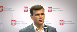 Minister wypowiada się do mikrofonu
