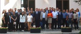Zdjęcie zbiorowe, przed budynkiem stoi duża grupa ludzi.