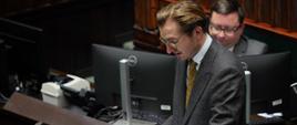 Wiceminister funduszy i polityki regionalnej Jan Szyszko stoi na mównicy sejmowej i czyta z kartki