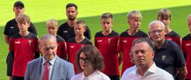 Zdjęcie z konferencji prasowej. Za mikrofonami na murawie stoją Wojciech Saługa, marszałek województwa śląskiego, Ewa Weber, pełniąca funkcję prezydenta Miasta Zabrze i wiceminister sportu i turystyki Piotr Borys. Za ich plecami stoją zawodnicy i trenerzy.