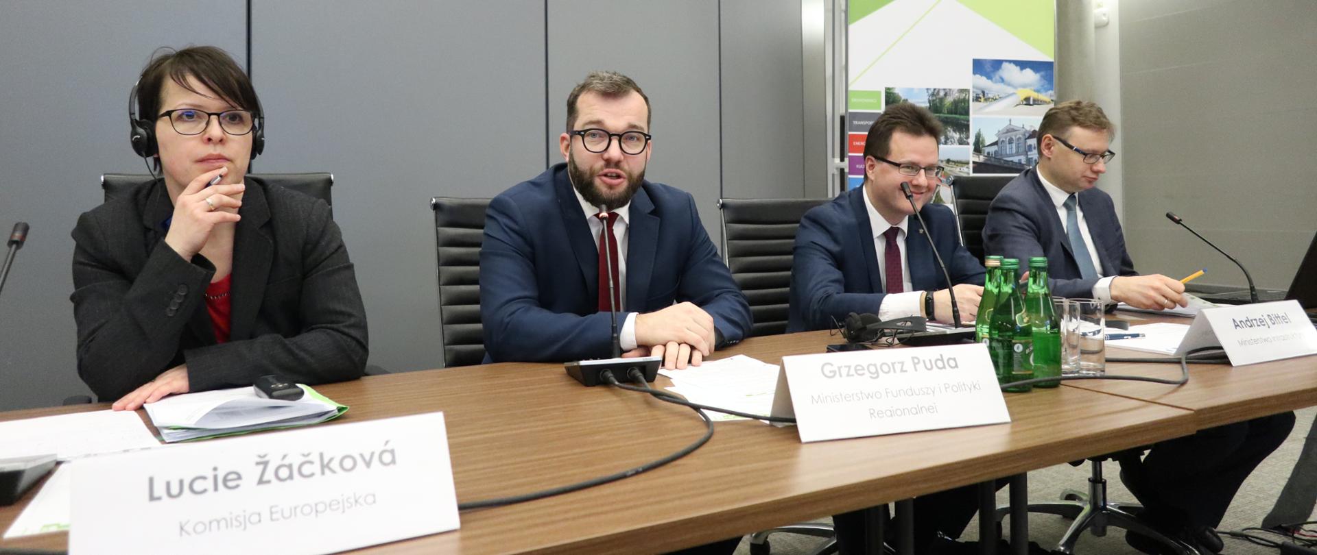 przy stole siedzą uczestnicy spotkania do mikrofonu mówi wiceminister Grzegorz Puda