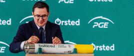 Minister Energii Miłosz Motyka składa podpis