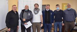 Sześciu mężczyzn stoi w szeregu w pomieszczeniu. Wiceminister Edukacji i Nauki to jeden z nich.