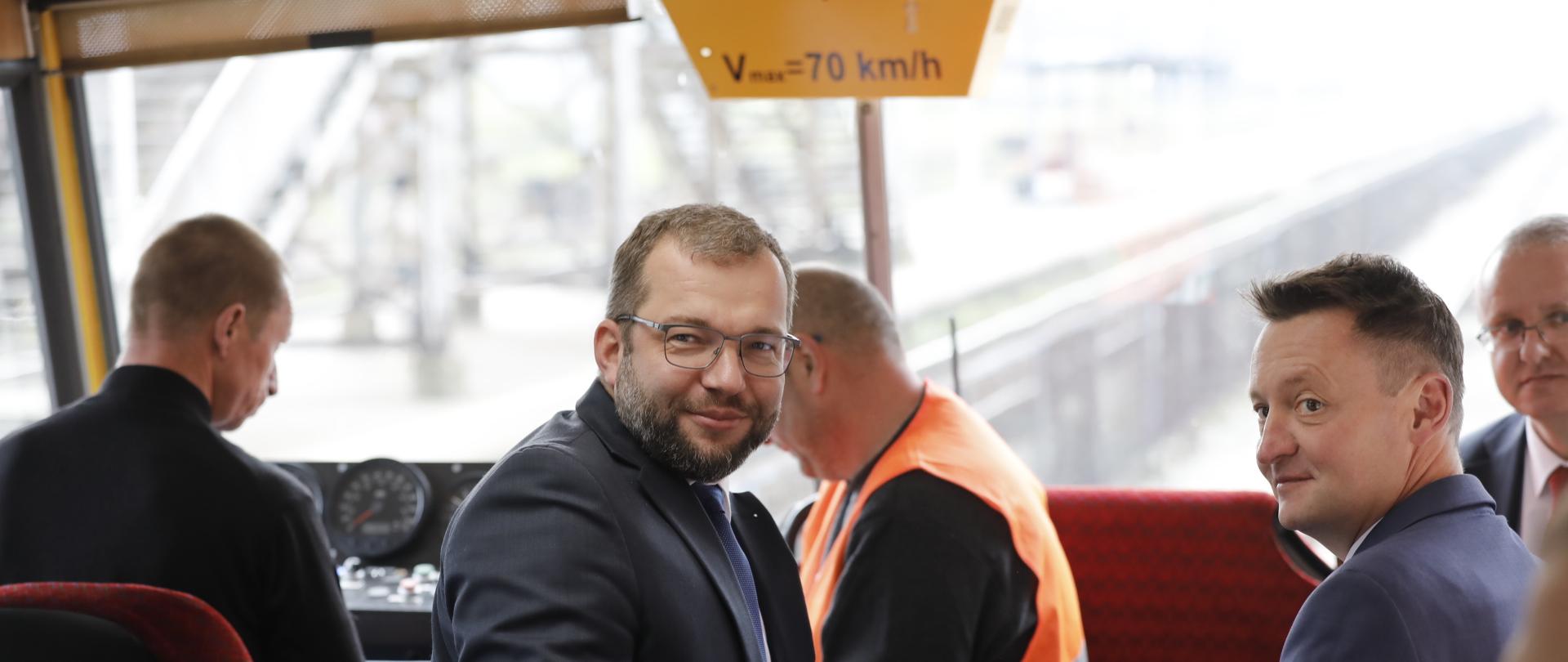 Minister Grzegorz Puda siedzi na krześle w drezynie.