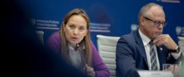 Minister funduszy i polityki regionalnej Katarzyna Pełczyńska-Nałęcz i wiceminister funduszy i polityki regionalnej Jacek Protas na spotkaniu z marszałkami województw, minister siedzi przy stole i przemawia do mikrofonu, obok niej wiceminister funduszy i polityki regionalnej Jacek Protas