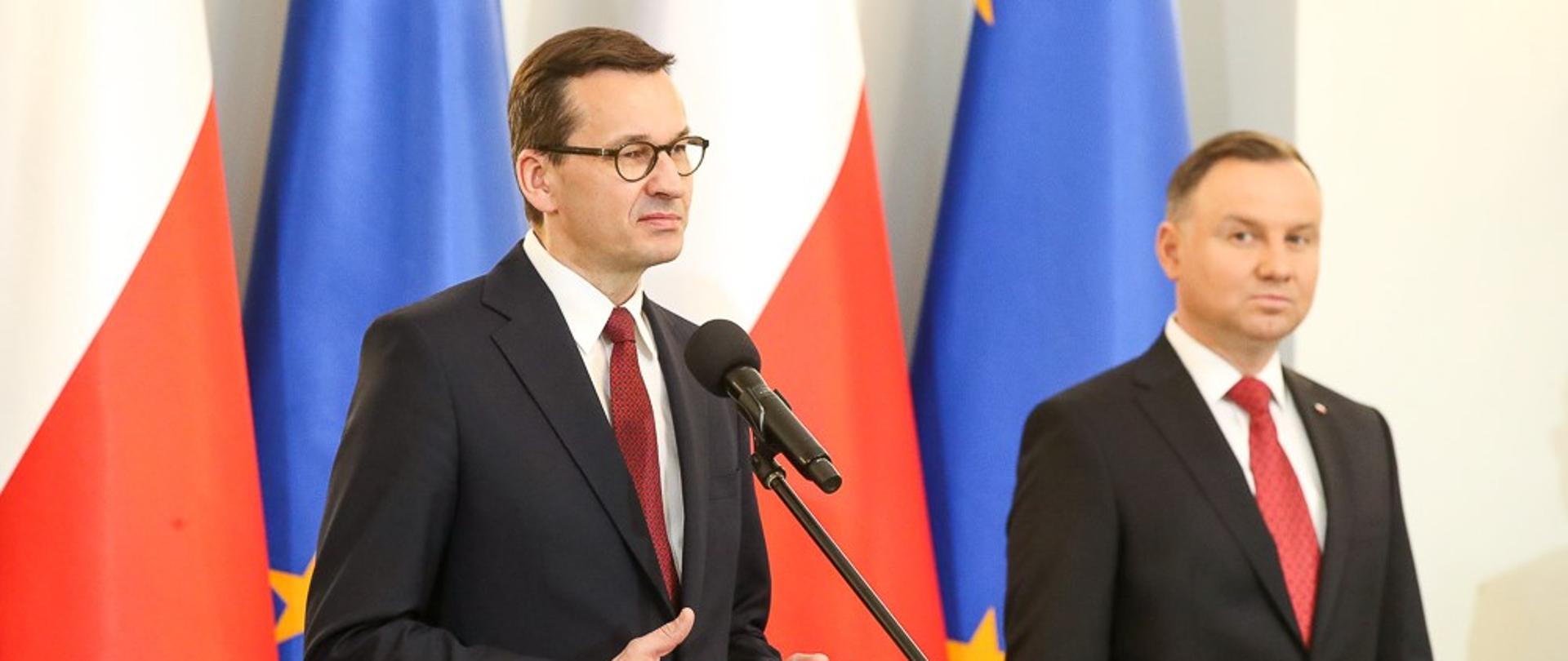 Premier przemawia, w tle stoi prezydent.