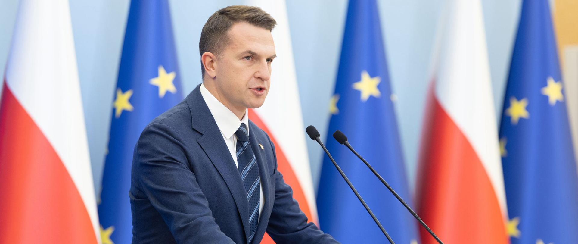 Konferencja prasowa Rzecznika Rządu Min. Adama Szłapki, 17.12.2025 r. Konferencja prasowa Rzecznika Rządu Min. Adama Szłapki, 17.12.2025 r. W tle flagi Polski i Unii Europejskiej.