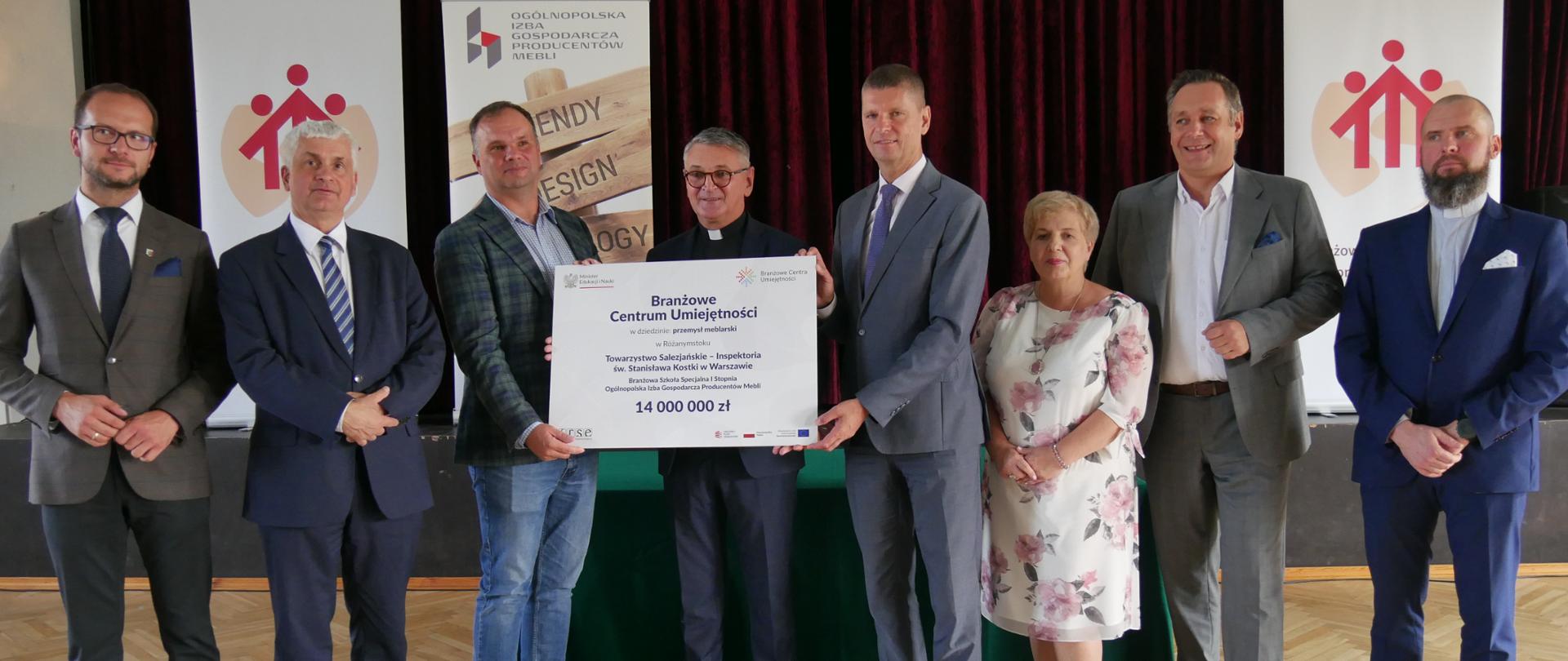 Grupa osób trzymających duży czek