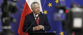 Prezes Łódzkiej Specjalnej Strefy Ekonomicznej Marek Michalik przemawia do mikrofonu, za plecami prezesa baner MFiPR i fagi Polski i UE