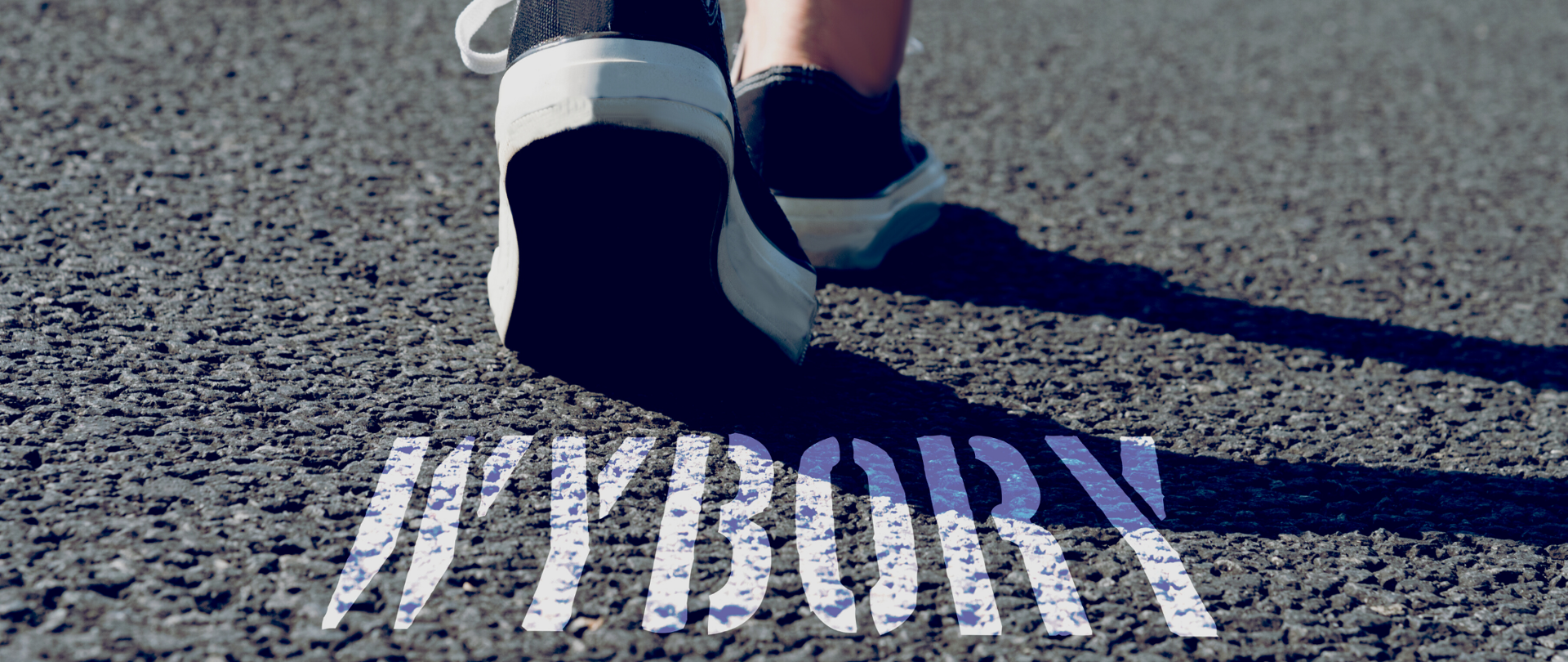 Bliskie ujęcie ulicy. N asfalcie biały napis WYBORY. Nad napisem trampki idącej osoby. 