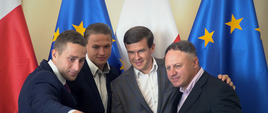 3 zawodników robi sobie zdjęcie z ministrem telefonem