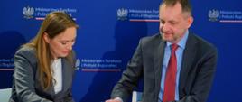 Minister funduszy i polityki regionalnej Katarzyna Pełczyńska-Nałęcz i członek zarządu BGK Tomasz Robaczyński podpisują umowę na wsparcie zielonej transformacji miast 