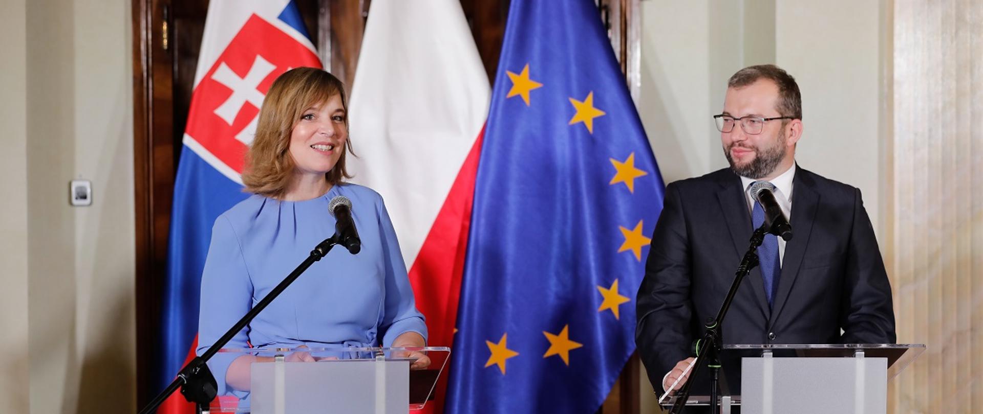 Minister funduszy i polityki regionalnej Grzegorz Puda i wicepremier Słowacji Wicepremier Veronika Remišova na konferencji otwierającej program Interreg Polska-Słowacja 2021-2027, ministrowie stoją przy mównicach, za ich plecami flagi UE, Polski i Słowacji 