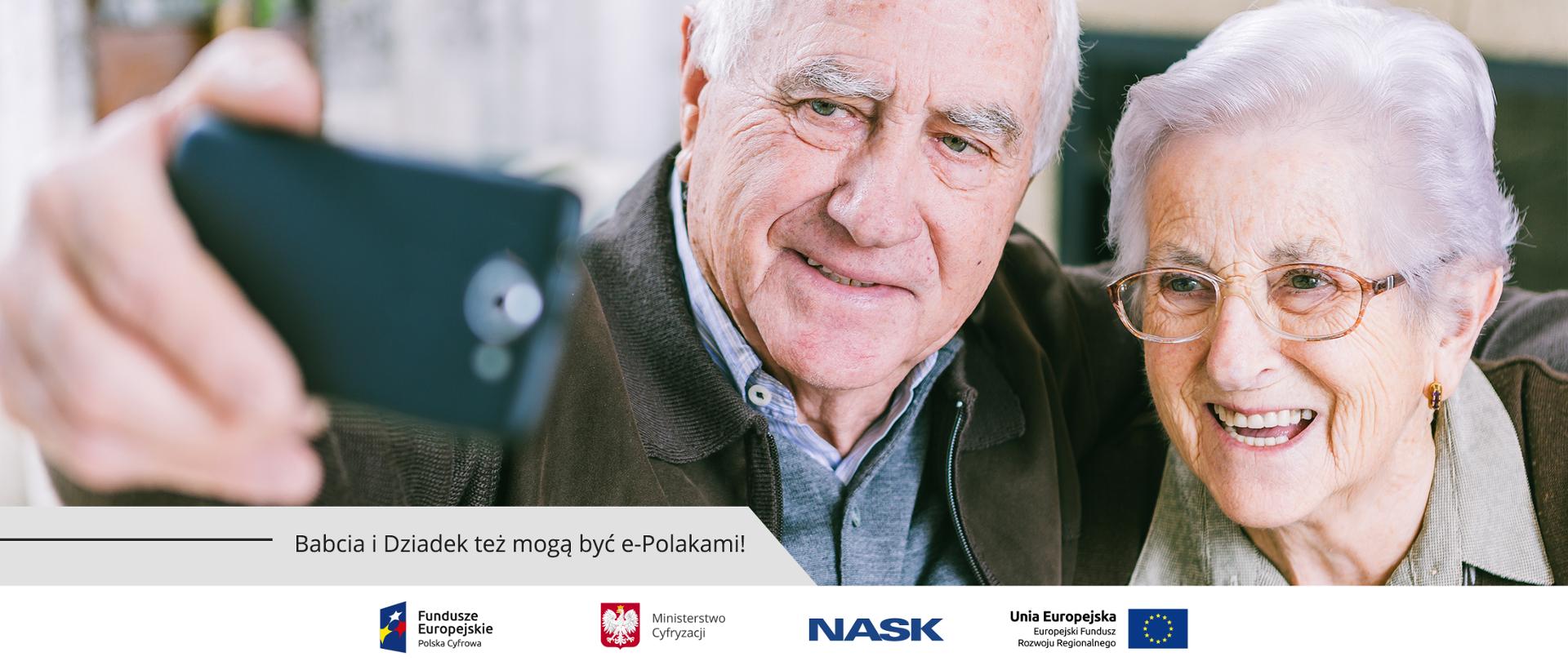 Grafika. Babcia i dziadek robią sobie zdjęcie telefonem komórkowym. Poniżej napis: Babcia i Dziadek tez mogą być e-Polakami!