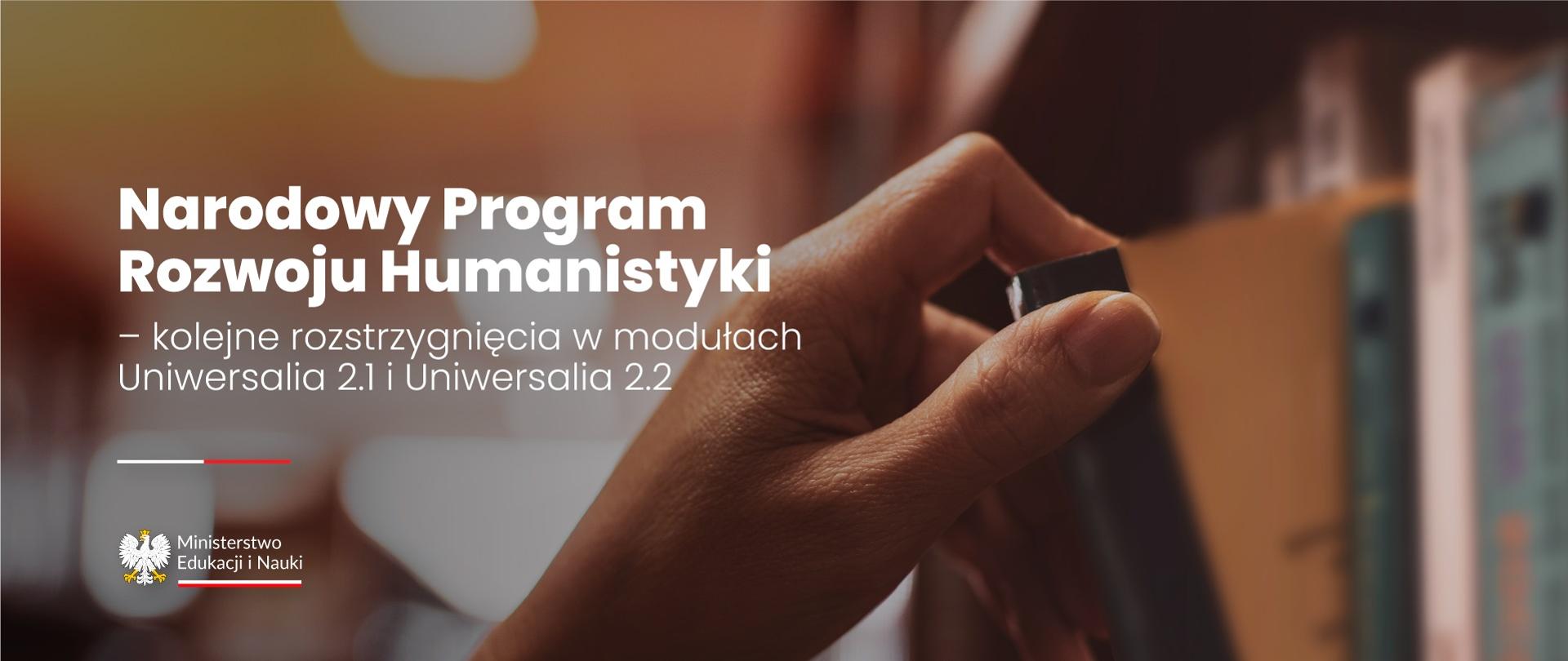 Ręka wyjmująca książkę z bibliotecznej półki, obok napis Narodowy Program Rozwoju Humanistyki - kolejne rozstrzygnięcia w modułach Uniwersalia 2.1 i 2.2.