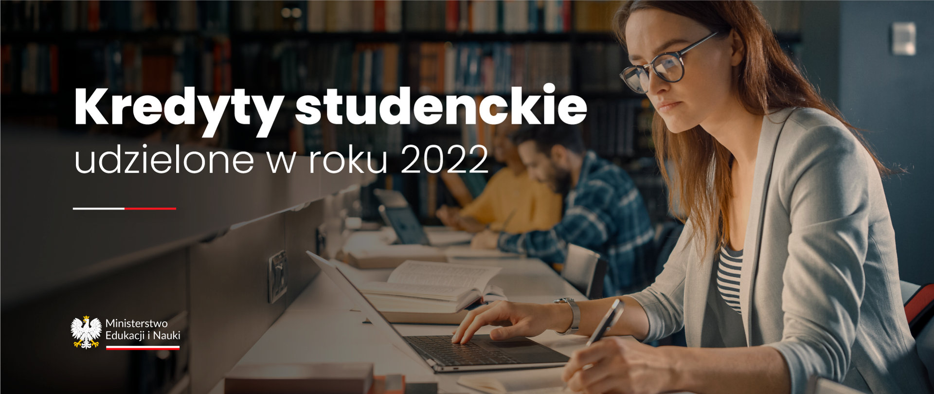 Napis Kredyty studenckie udzielone w roku 2022. W tle grupa osób w bibliotece pracująca na komputerach. 