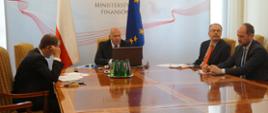 Minister Tadeusz Kościński wraz ze swoimi współpracownikami na tle banera Ministerstwa Finansów