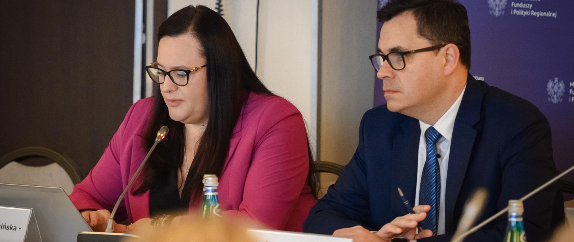 Wiceminister Małgorzata Jarosińska-Jedynak i dyrektor Piotr Krasuski przy stole z mikrofonami