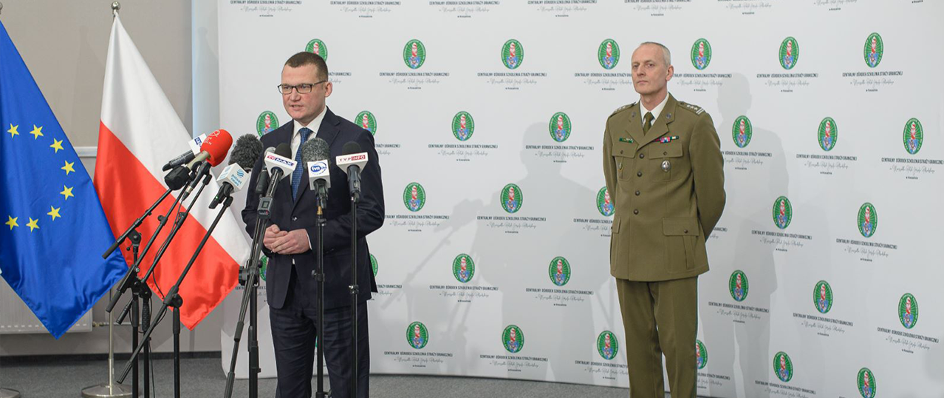 Wiceminister Paweł Szefernaker podczas konferencji prasowej poświęconej utworzeniu Wyższej Szkoły Straży Granicznej, a za nim komendant Centralnego Ośrodka Szkolenia SG płk SG dr Piotr Boćko.