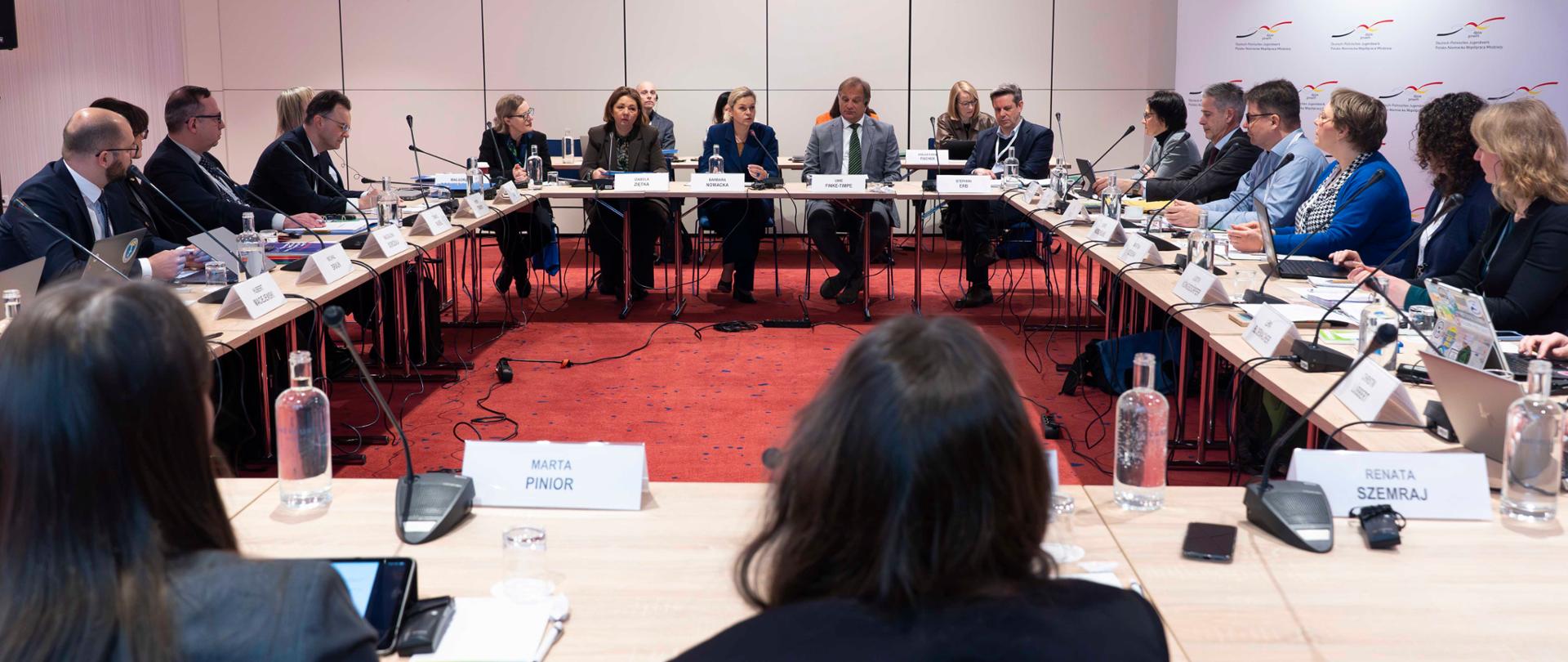 Na zdjęciu Minister Edukacji Barbara Nowacka, Podsekretarz Stanu Izabela Ziętka, Uwe Finke-Tempe, Kierownik Referatu Międzynarodowej i Europejskiej Polityki Młodzieżowej w Federalnym Ministerstwie ds. Rodziny, Seniorów, Kobiet i Młodzieży oraz inni uczestnicy XXXV posiedzenia Rady Polsko-Niemieckiej Współpracy Młodzieży. Wszyscy siedzą przy wspólnym stole.