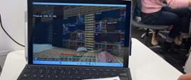 Widok na ekran laptopa, na którym widać obraz z gry.