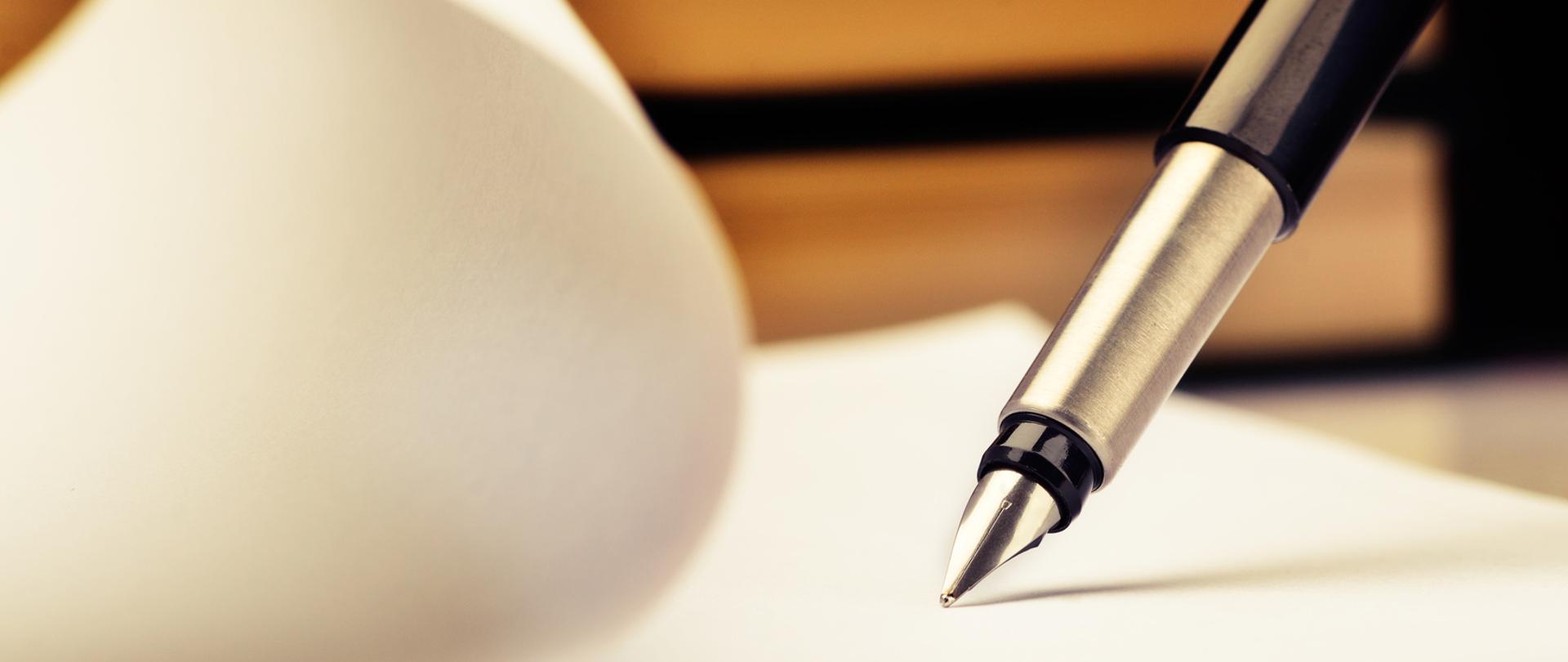 Szaro czarne wieczne pióro dotyka kartki papieru