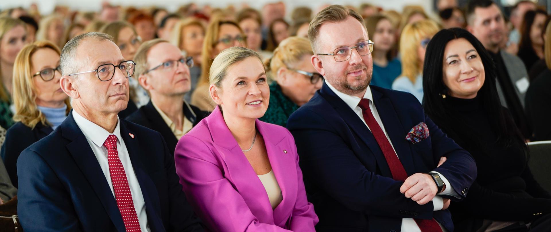 Minister Edukacji przysłuchuje się wystąpieniu razem z innymi uczestnikami