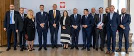 Minister Finansów wraz ze współpracownikami i przedstawicielami banku Pekao na tle ścianki Ministerstwa Finansów