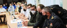 Premier oraz pozostali siedzą przy stole.