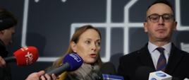 
Na zdjęciu minister Katarzyna Pełczyńska-Nałęcz przed mikrofonami odpowiada na pytania dziennikarzy, obok stoi Minister Infrastruktury Dariusz klimczak
